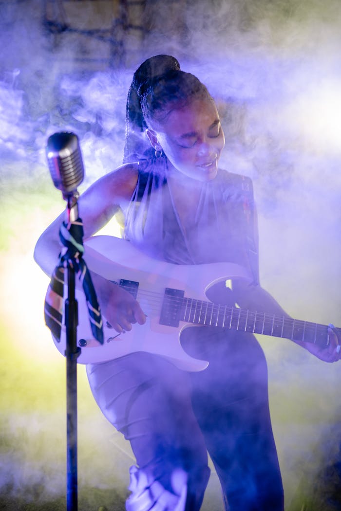 Mastering the First Impression: Your intriguing post title goes here A vibrant live performance featuring a skilled female guitarist amid colorful stage lighting and smoke.